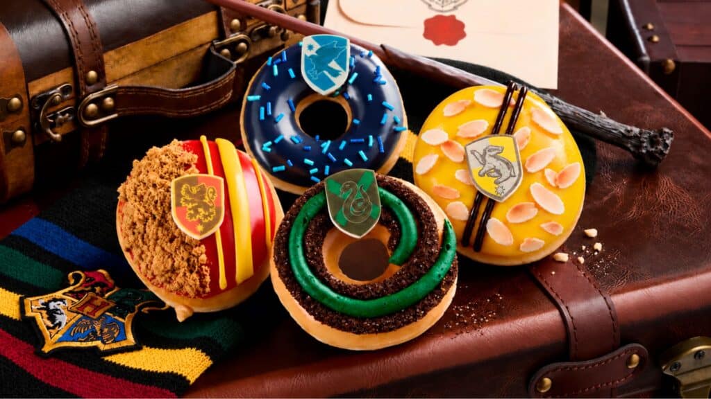 Krispy Kreme lança donuts inspirados em Harry Potter Donuts da Krispy Kreme inspirados em Harry Potter com glacês verde e azul sobre tecido temático