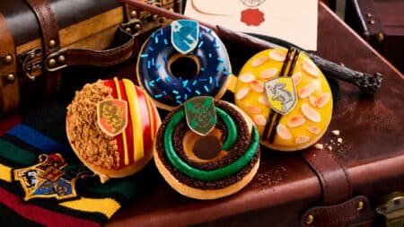 Krispy Kreme lança donuts inspirados em Harry Potter Donuts da Krispy Kreme inspirados em Harry Potter com glacês verde e azul sobre tecido temático