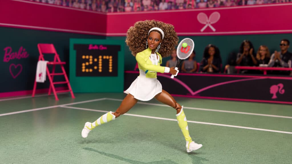 Barbie jogando tênis em quadra verde Boneca Barbie jogando tênis em quadra verde, com plateia ao fundo e raquete na mão