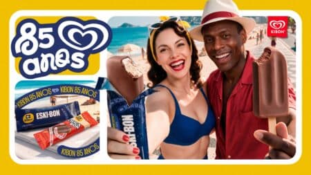 Imagem promocional da Kibon com casal sorridente e sorvetes; embalagem limitada celebra 85 anos com Chicabon e Eski-bon.