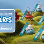 Imagem promocional da Kopenhagen com chaveiros colecionáveis dos Smurfs na grama, com personagens e cartão “Compre e ganhe os Smurfs”.
