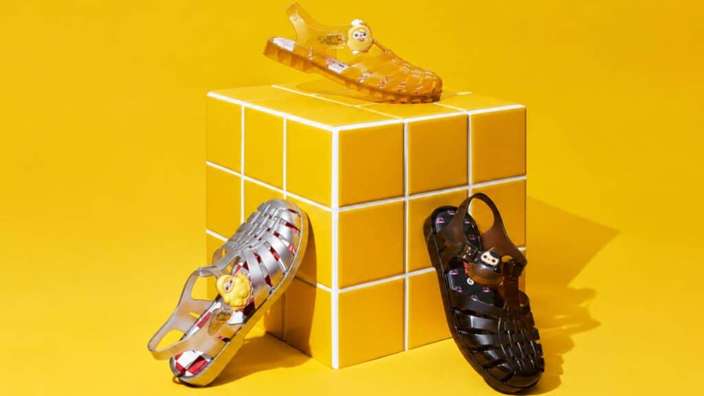 Tênis e sapatos estilo boneco em miniatura sobre cubos amarelos da collab Melissa e POP MART inspirada na PUCKY.
