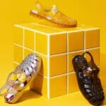 Tênis e sapatos estilo boneco em miniatura sobre cubos amarelos da collab Melissa e POP MART inspirada na PUCKY.