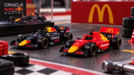 Miniaturas de carros de F1 no McDonald’s Brasil Miniaturas de carros de Fórmula 1 da Red Bull e McDonald's em pista, com logotipo do McDonald’s ao fundo.