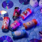 Embalagens de chá-mate Hello Kitty and Friends da PeD Bebidas sobre fundo azul com discos holográficos