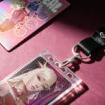 Chaveiros e cards temáticos da Riot Games em cenário rosa, com personagens do universo K-POP e pop-up store.