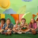 Crianças reunidas em área externa com bichinhos de pelúcia, na campanha do Sicredi Serrana para incentivar a poupança infantil.