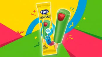 Picolé Fini Minhocas com cobertura verde e recheio push Picolé Fini Minhocas em embalagem e palito, com cobertura verde e imagem do personagem azul, sobre fundo colorido