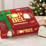 Embalagem do marshmallow TopBel Natal com wafer e chocolate ao leite, ao lado de um pacotinho aberto em decoração de Natal